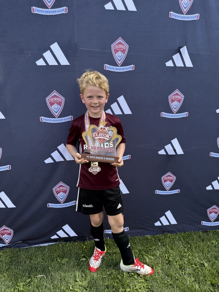 Jackson holding a championship trophy in his Rapids kit